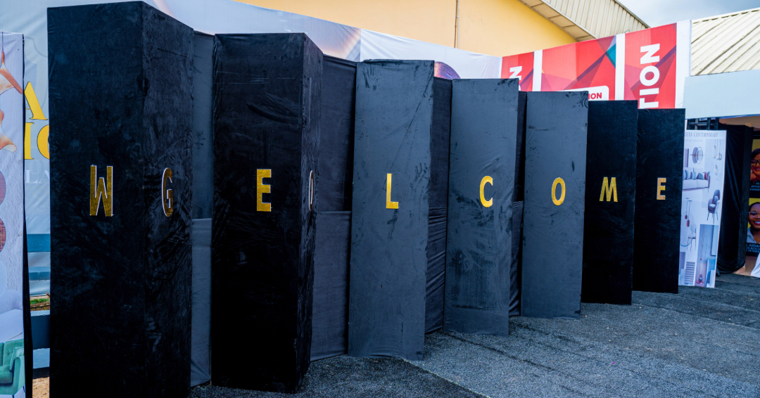 Black vertical panels arranged in a wave-like formation with gold letters spelling 'WELCOME'.